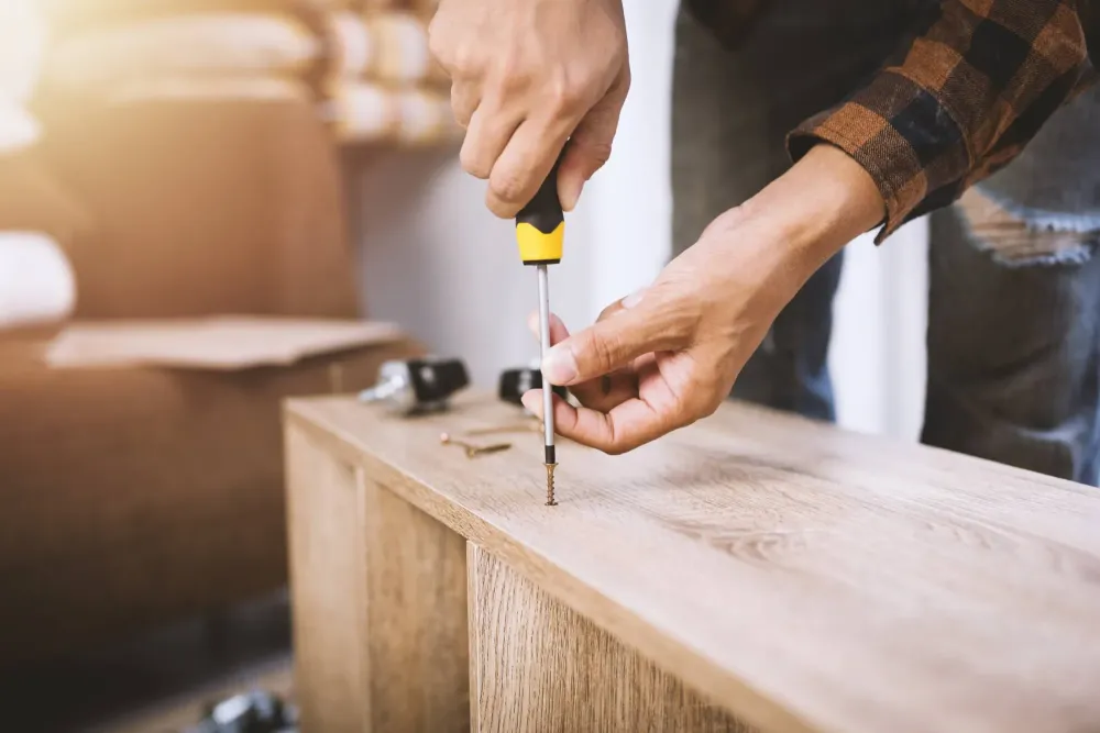 artisan montant un meuble en bois