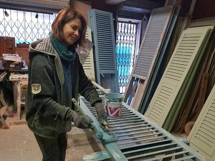 Artisan peignant une persienne