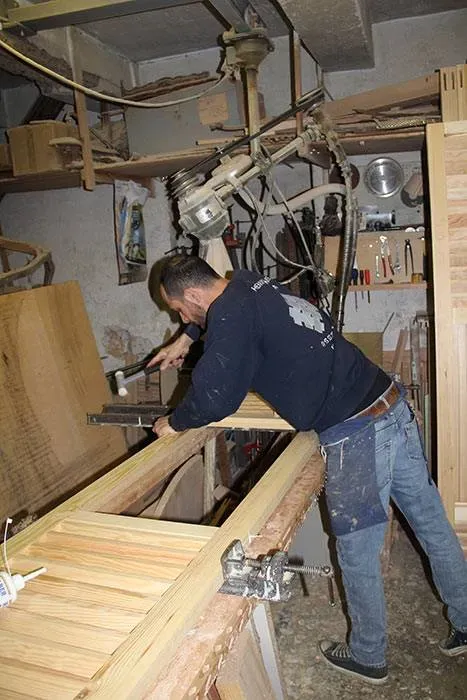 artisan montant un meuble en bois